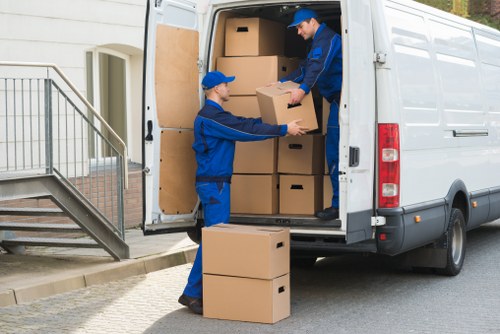 Professional movers carrying belongings down stairs in a Pimlico flat building